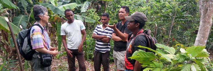 Männer stehen auf einer landwirtschaftlich genutzten Parzelle im Kreis