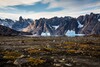 Mit Schnee bedeckte Berge erheben sich aus karger Landschaft