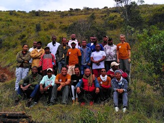 Mehrere Personen sitzen auf einer landwirtschaftlichen Parzelle in Ankafobe auf Madagaskar für ein Gruppenbild