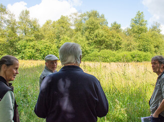 Personen im Gespräch auf einer Moorfläche