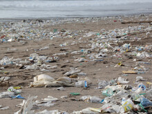 Plastikmüll liegt angeschwemmt an einem Sandstrand