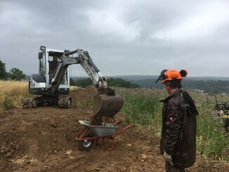 Traktor kippt Erde in Schubkarre