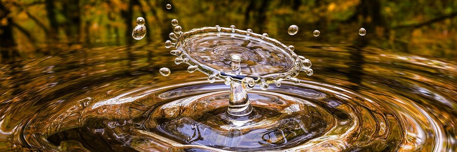Wassertropfen fällt auf Wasseroberfläche