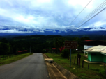 Straße in Dorf in Costa Rica vor dem Hintergrund dicht mit Wald bewachsener Berge