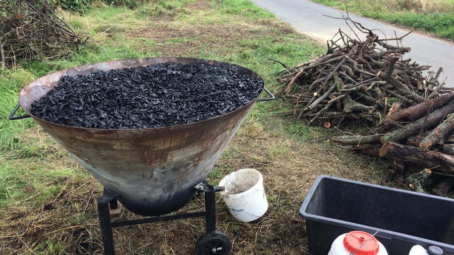 Kiln ist bis zum Rand gefüllt mit frisch hergestellter Pflanzenkohle