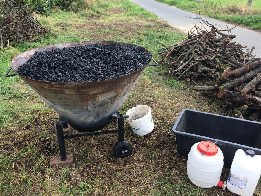 Kiln ist bis zum Rand gefüllt mit frisch hergestellter Pflanzenkohle