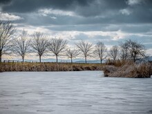 Winterlandschaft – See mit Baeumen