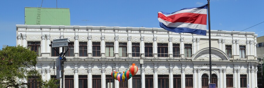 Weißtes Haus hinter wehender Costa Ricanischer Flagge