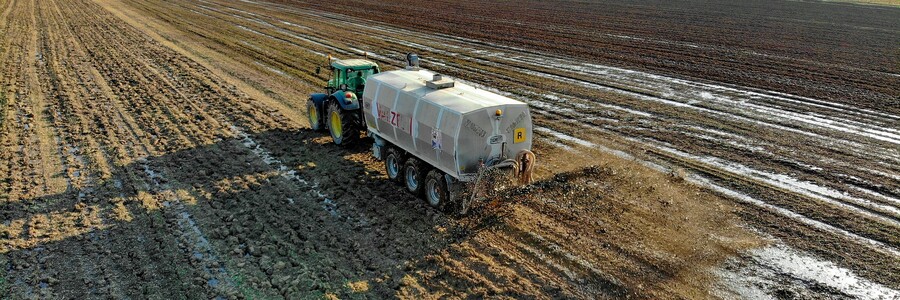 Gülle wird von Traktor auf Acker ausgebracht
